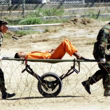 مشهد نقل سجين في سجن غوانتانمو بعد تعرضه للتغذية القسرية